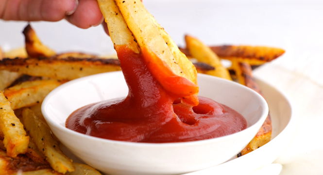 dipping baked french fries in ketchup