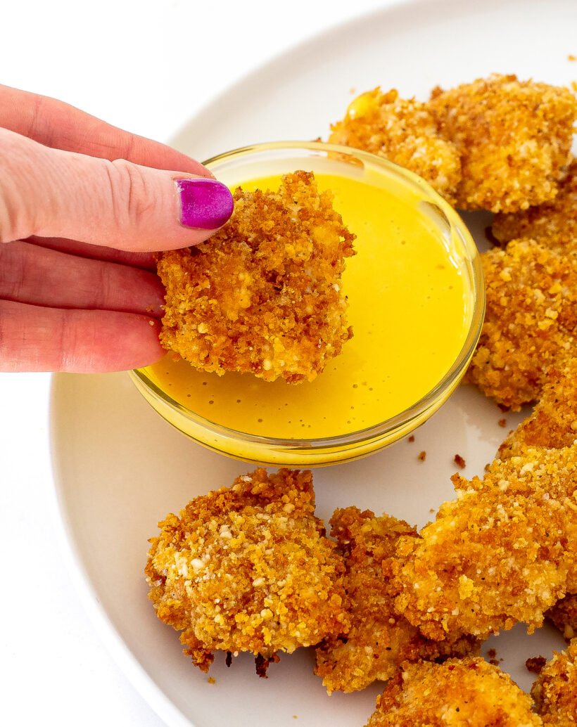 dipping chicken nuggets in honey mustard sauce