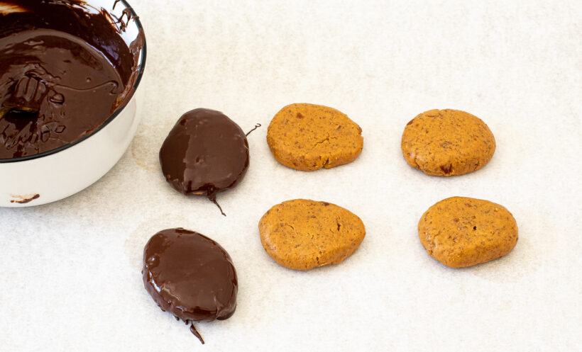 Peanut Butter eggs coated in chocolate next to eggs that are uncoated.