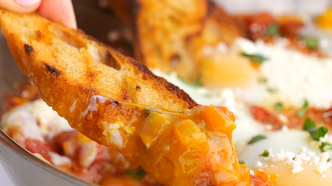 gooey up close shot of creamy egg yolk on toasted baguette