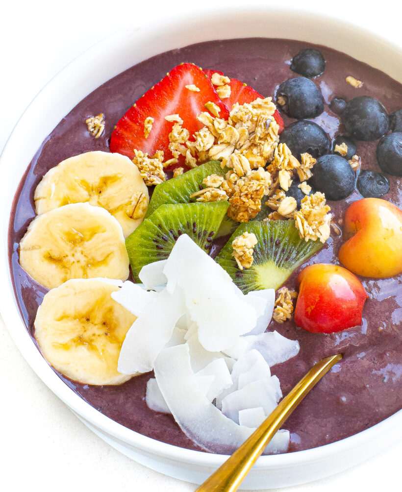 Acai bowl topped with a variety of fresh fruits, granola, and coconut. 