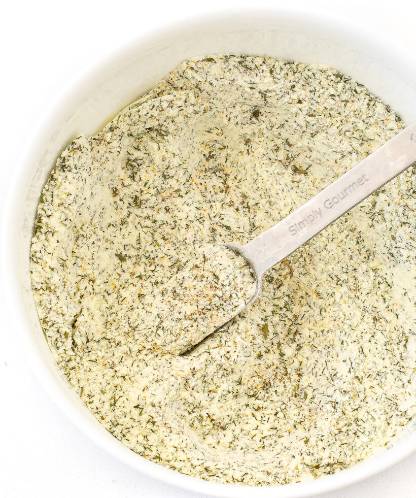 Overhead shot of ranch seasoning in a white bowl with a metal spoon. 