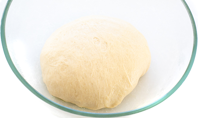 Dough in a clear mixing bowl. 