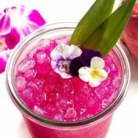 Dragon fruit margarita garnished with flowers.