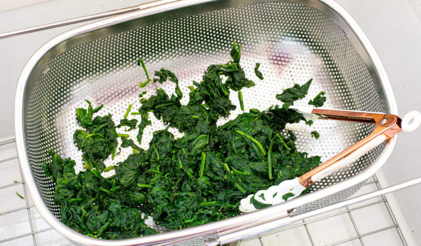 Spinach being drained in a colander. 