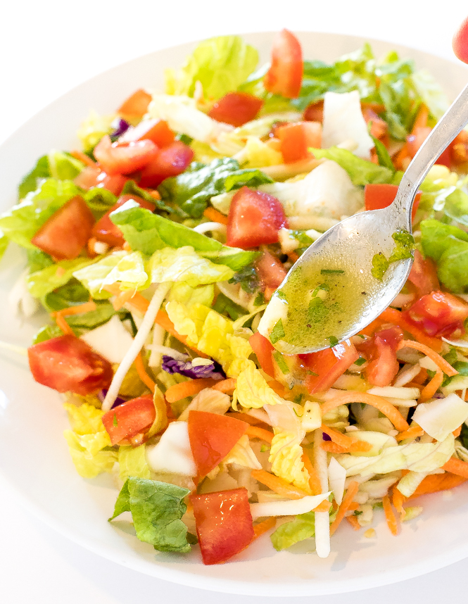 chopped salad with tomatoes, lettuce and cabbage drizzled with lemon vinaigrette