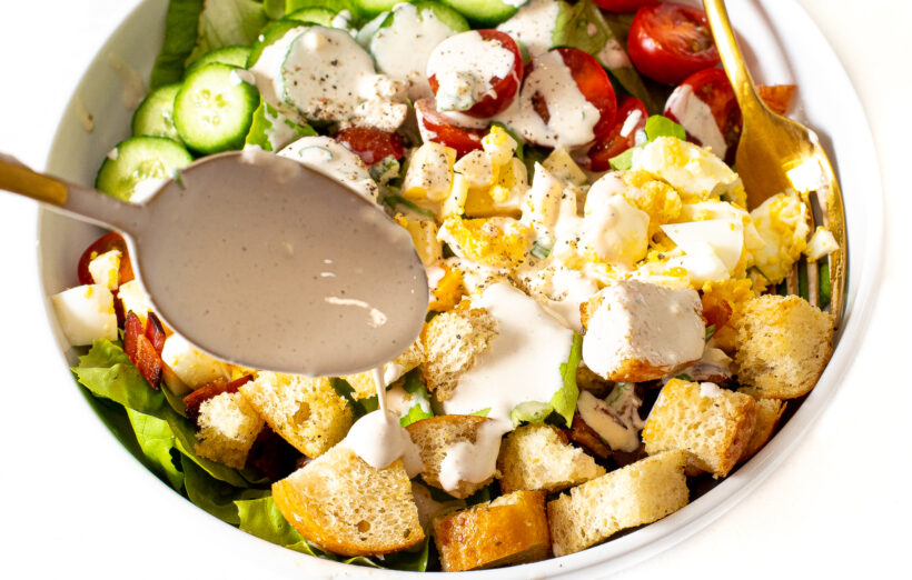 drizzling blue cheese dressing on top of salad