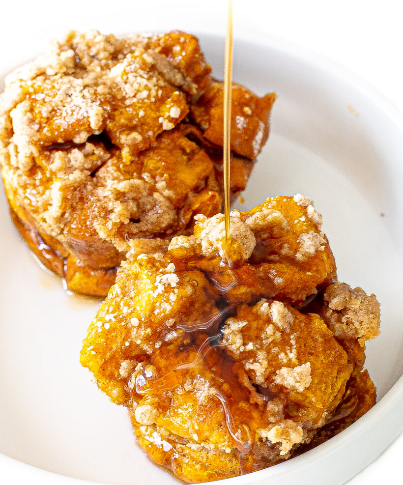 Two pumpkin french toast muffin cups with maple syrup drizzled on top.