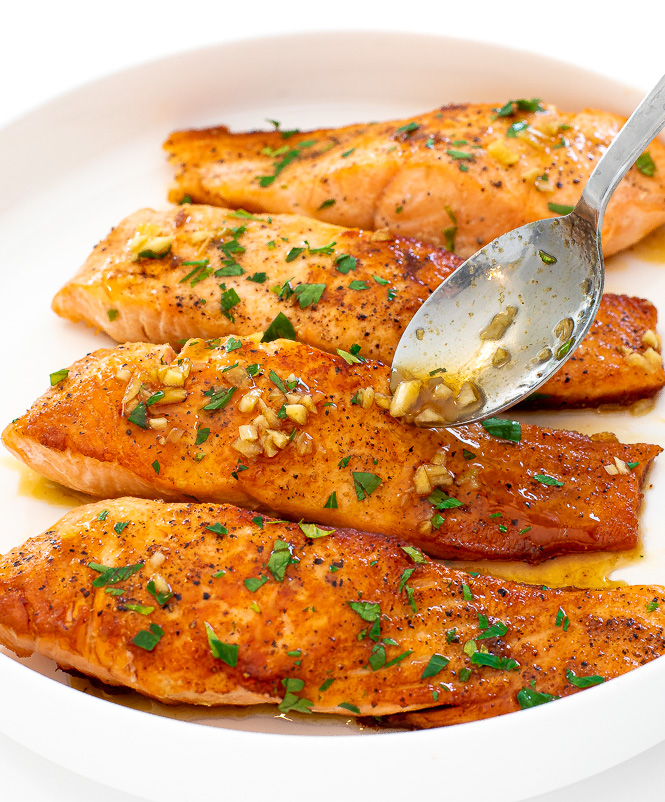 drizzling honey lemon garlic sauce on top of salmon