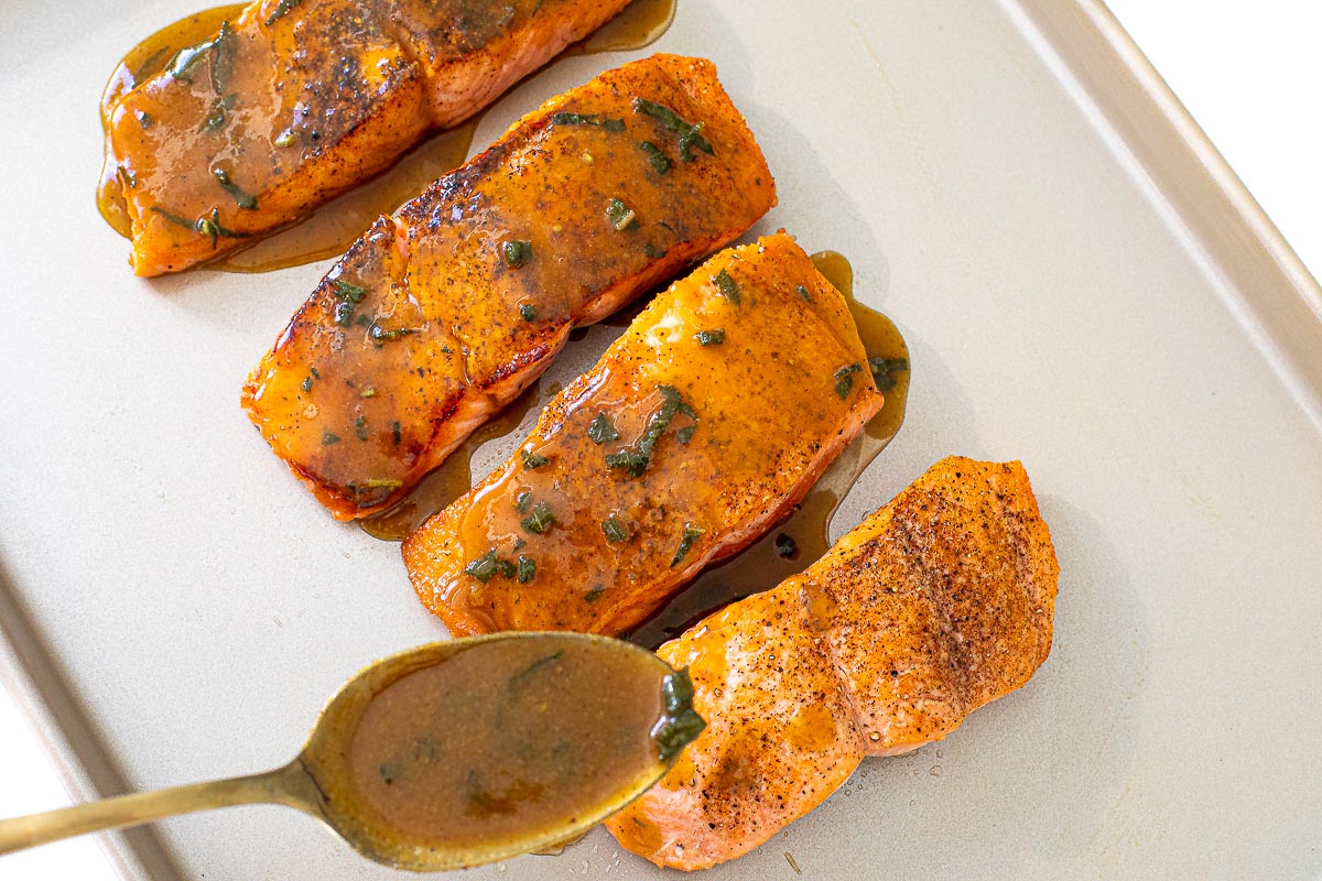 adding maple dijon sauce on to salmon
