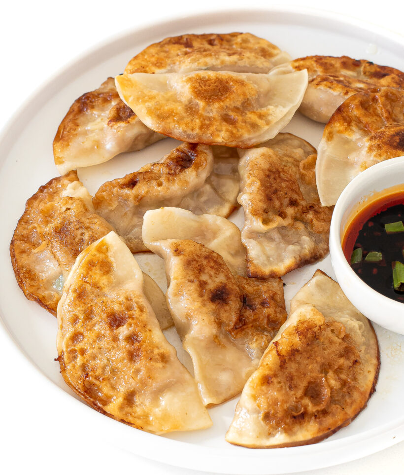 overhead shot of Chinese dumplings on plate with dipping sauce