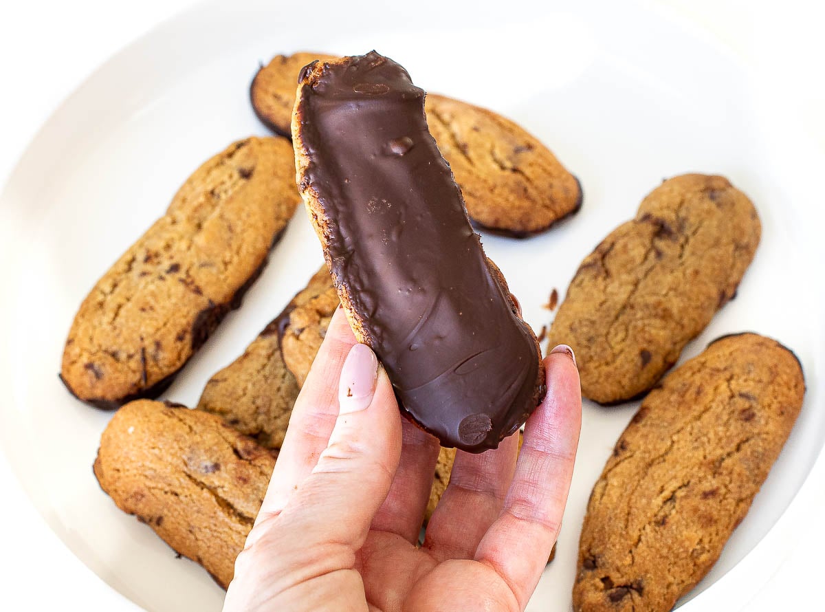 holding dunker cookie dipped in chocolate