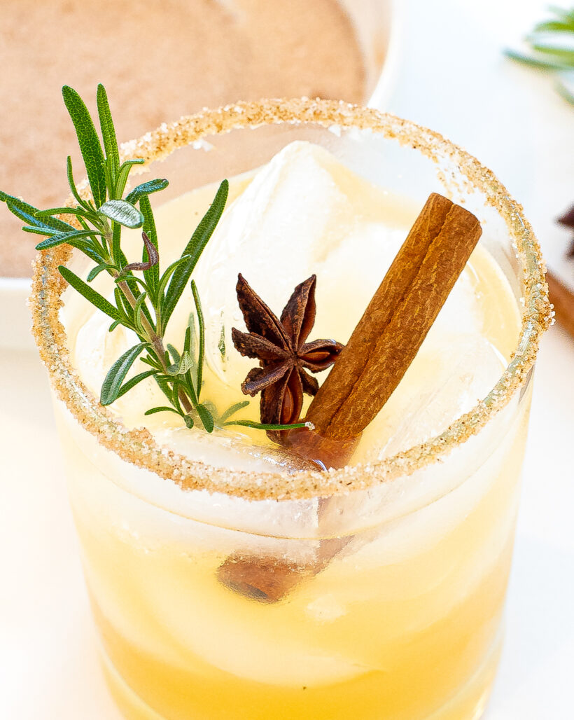 Apple cider margarita in a rocks glass with cinnamon sugar rim.
