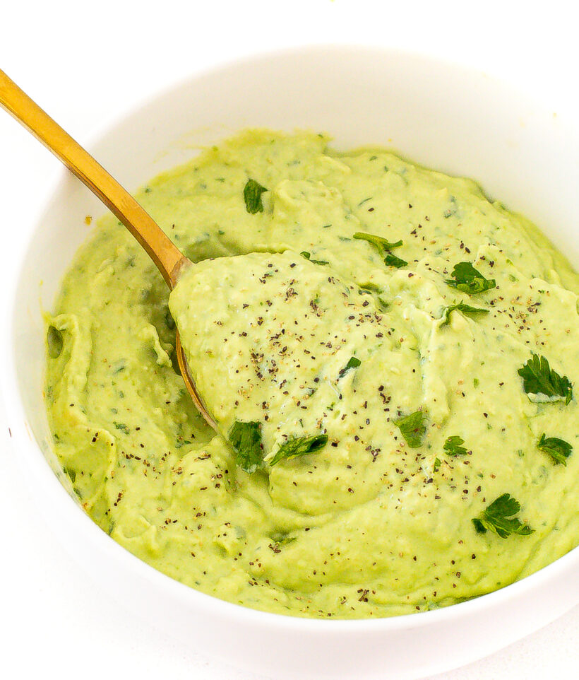 Abocado crema served in a small white bowl with a spoon. 