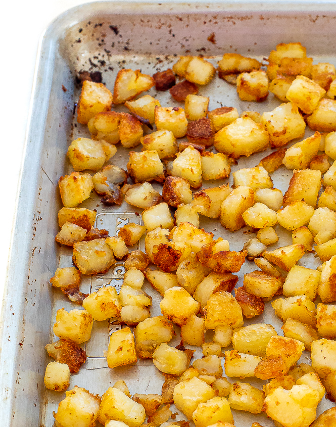 Up close shot of crispy breakfast potatoes on a baking sheet.