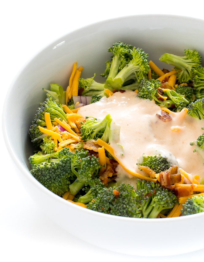 Broccoli Salad in a white bowl with broccoli salad dressing.