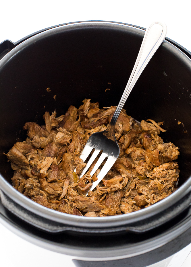 Pork Carnitas in an instant pot with a fork.