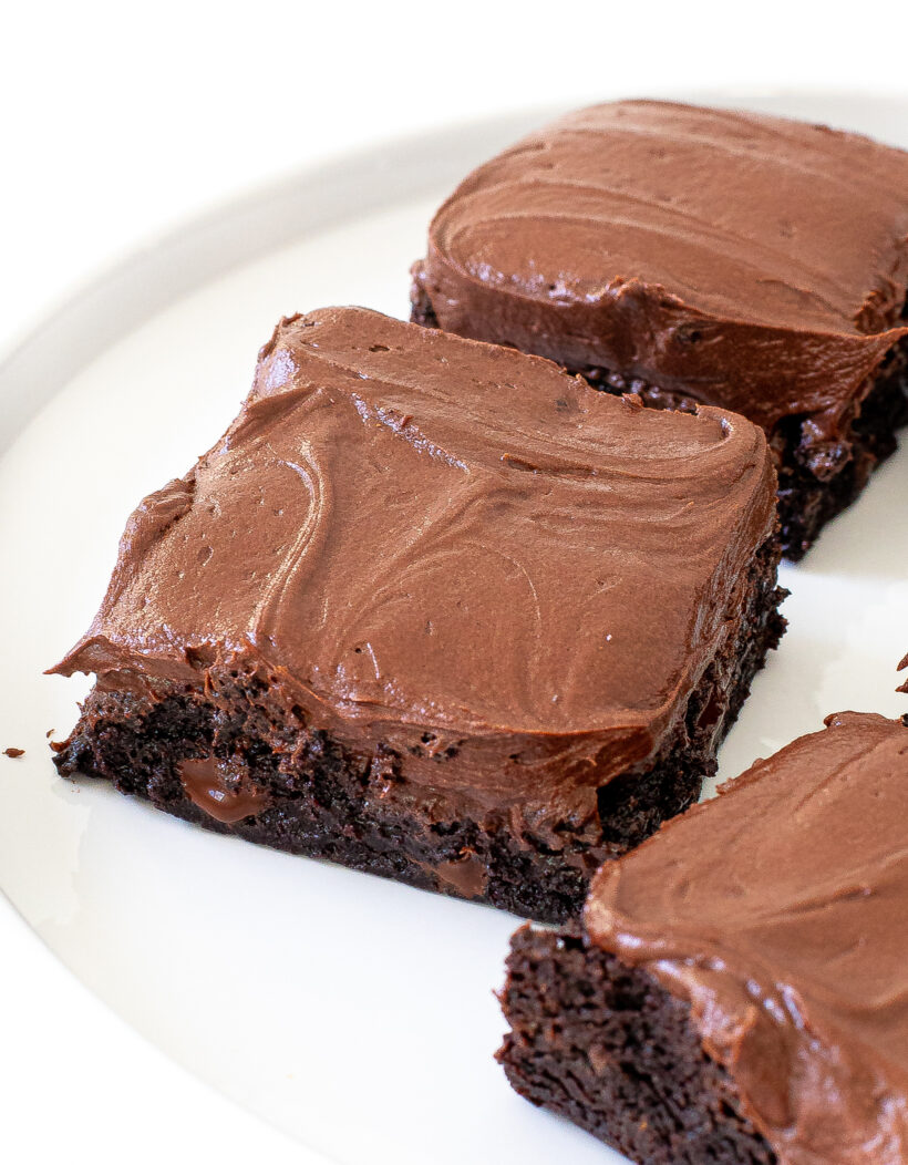 up close shot of chocolate brownies with chocolate buttercream frosting on top