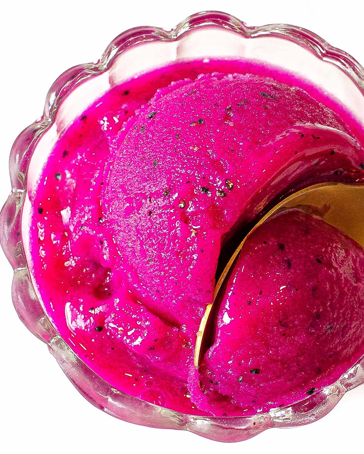 Scooping dragon fruit water ice with a spoon.