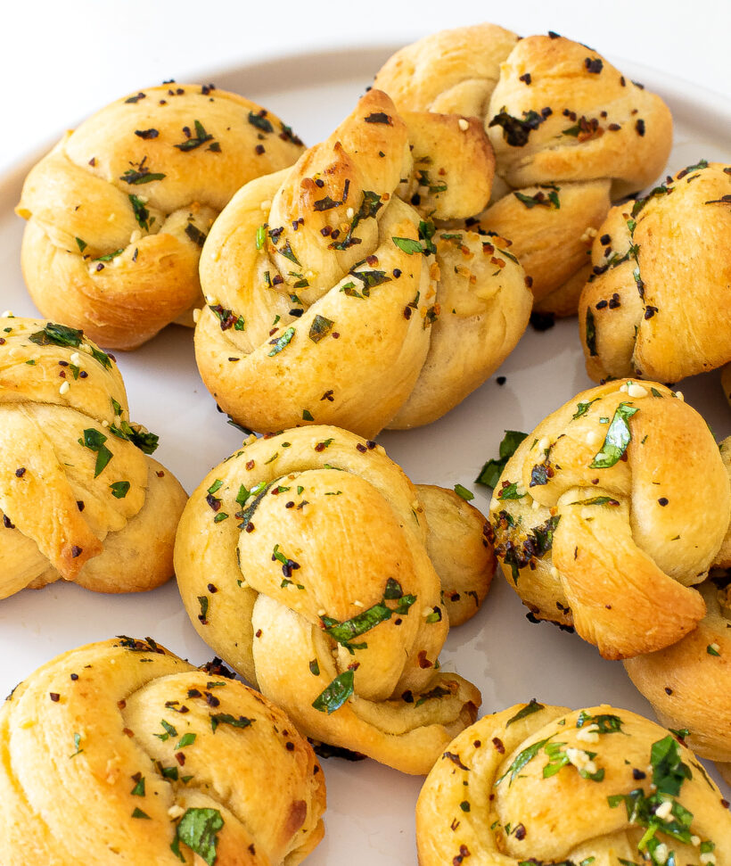 Up close shot of garlic knots on white plate.