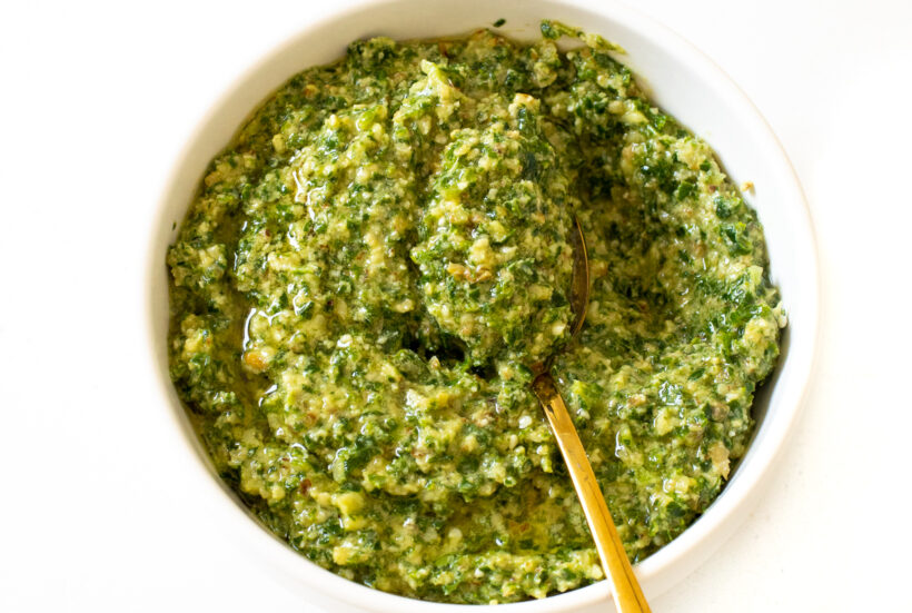 Kale pesto served in a bowl with a spoon.