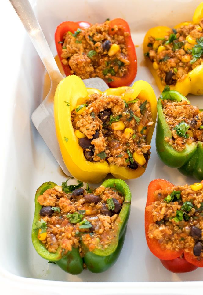 a closeup of these Healthy Mexican Quinoa and Turkey Stuffed Peppers in a white baking dish