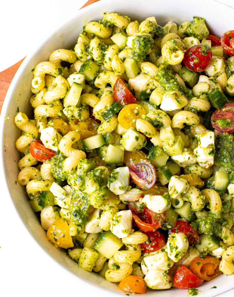 Pesto pasta salad in a white serving bowl.