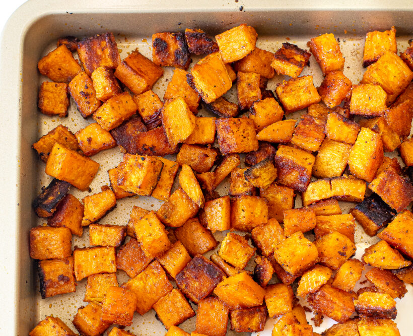 Roasted sweet potatoes on a sheet pan after being cooked.