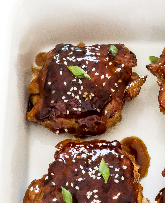 Easy Baked Teriyaki Chicken Thighs | chefsavvy.com Baked Teriyaki Chicken with sesame seeds and green onions on a white dish.