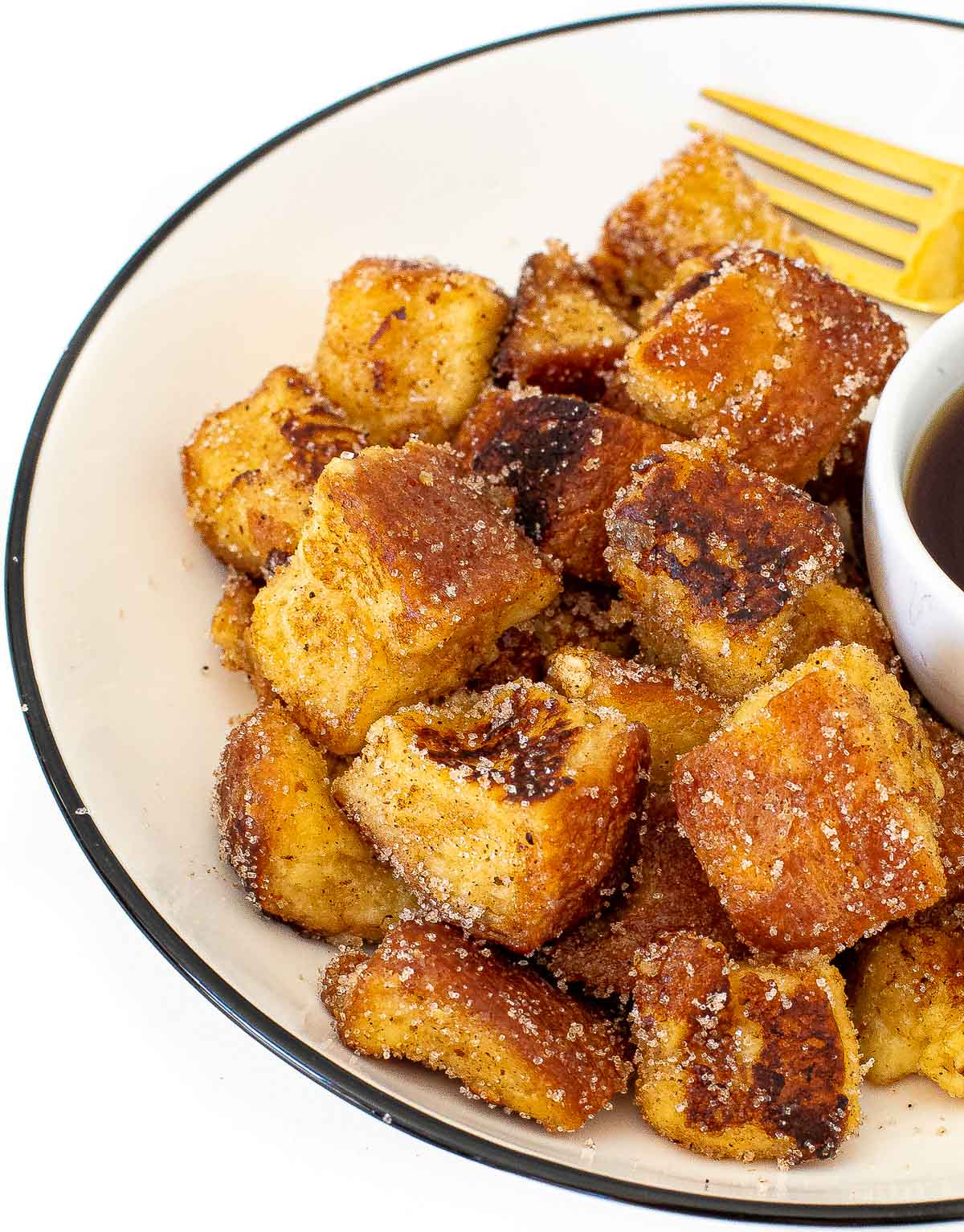eggnog French toast bites tossed in cinnamon and sugar on a white plate