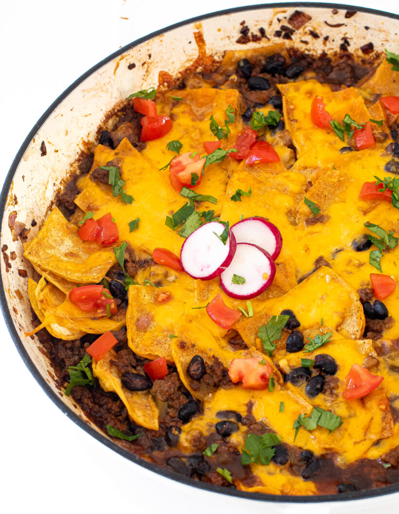 Beef enchilada skillet topped with tomatoes, cilantro and radishes. 