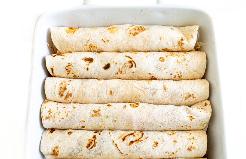 Tortillas rolled up in a baking pan.