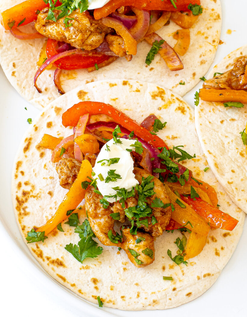 Warm flour tortillas topped with chicken fajita filling, dollop of sour cream and cilantro.