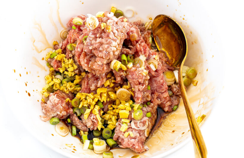 White mixing bowl filled with wonton filling.