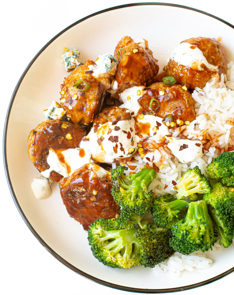 Firecracker meatballs with toppings on a white plate.