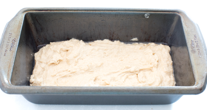spreading quick bread batter onto the bottom of the loaf pan