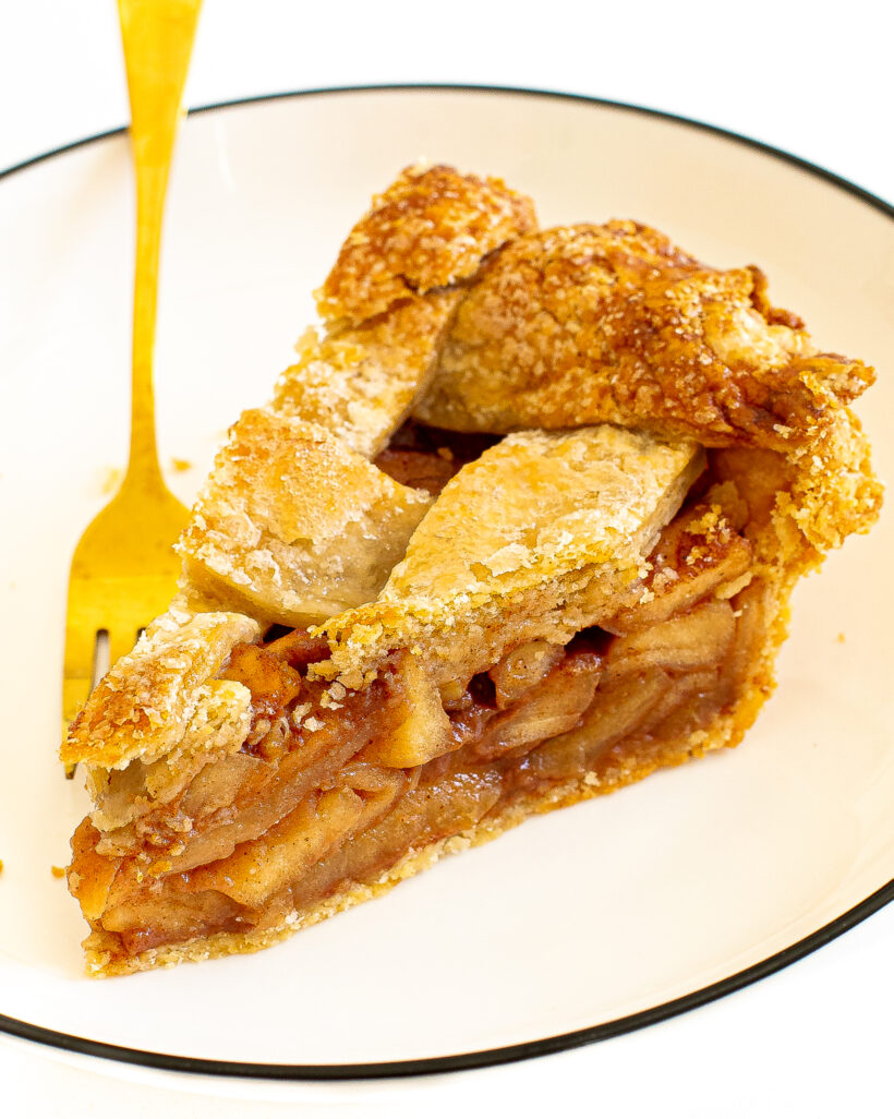 A slice of apple pie on a white plate.