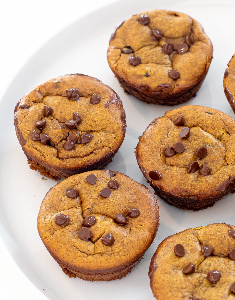 Pumpkin muffins lined up on a white serving tray.