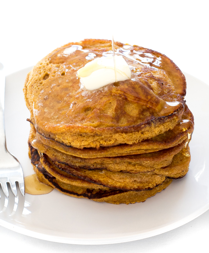 Light and Fluffy Pancakes | chefsavvy.com pumpkin pancakes on white plate with melted butter and maple syrup