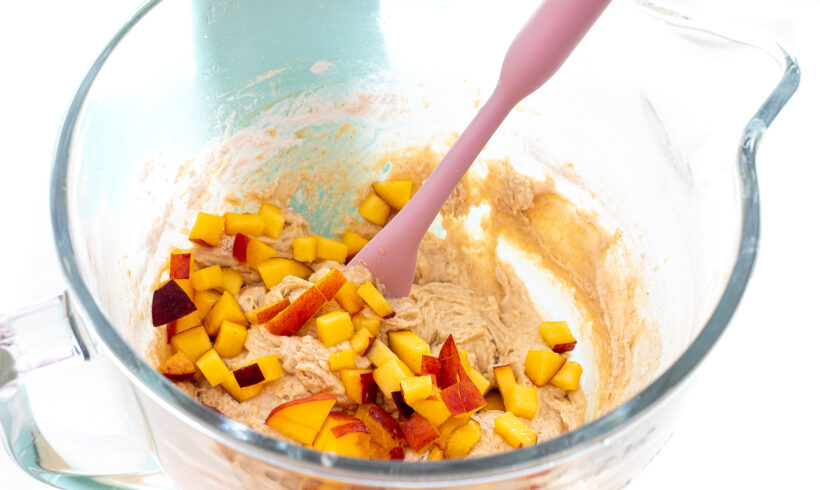adding diced peaches to cake batter