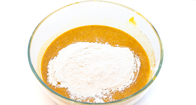 Wet ingredients in a glass bowl with the dry ingredients sitting on top.