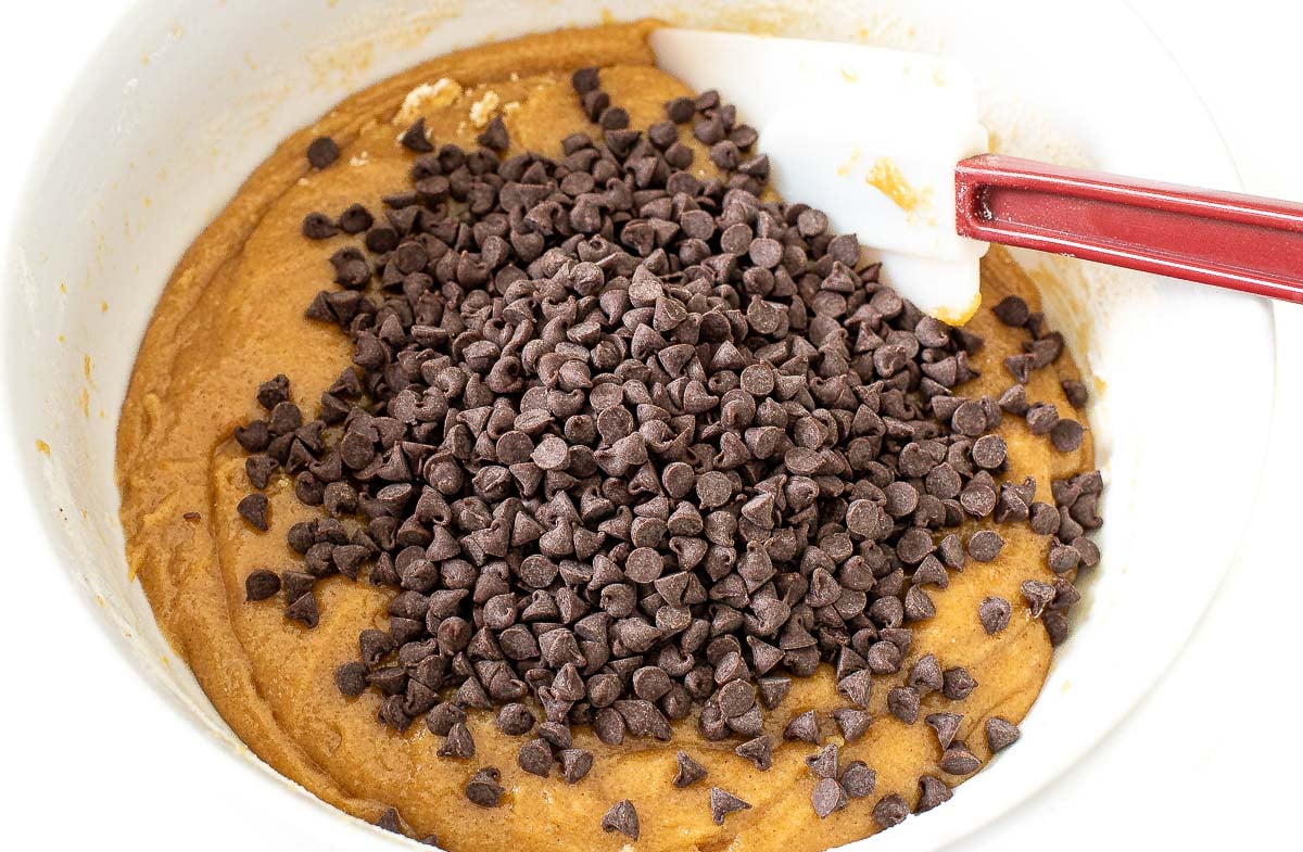 adding mini chocolate chips to white bowl