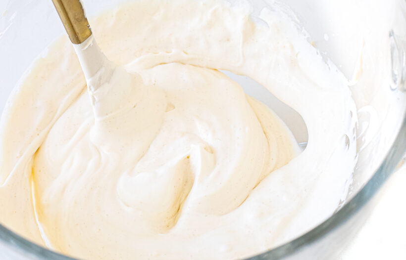 Spatula folding in whipped cream into the mascarpone mixture.