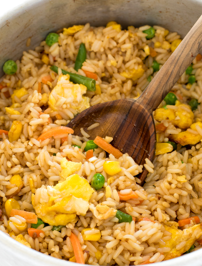 Air fryer fried rice in a pan with a wooden spoon.