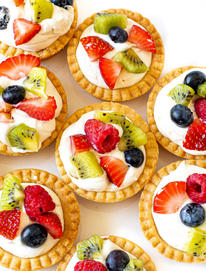 Mini fruit tarts topped with fresh fruit.