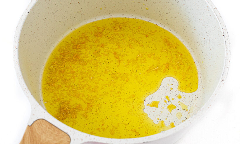 A skillet with olive oil and garlic.