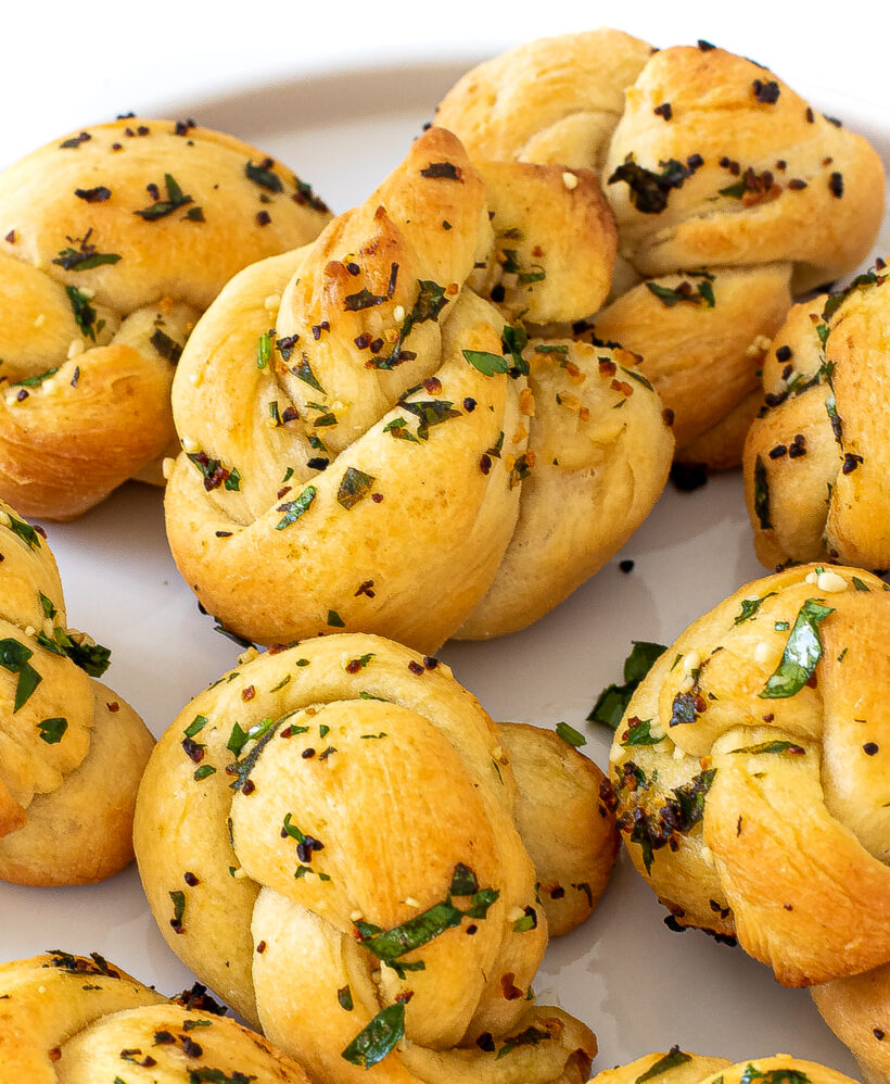 Garlic knots served on a white plate.