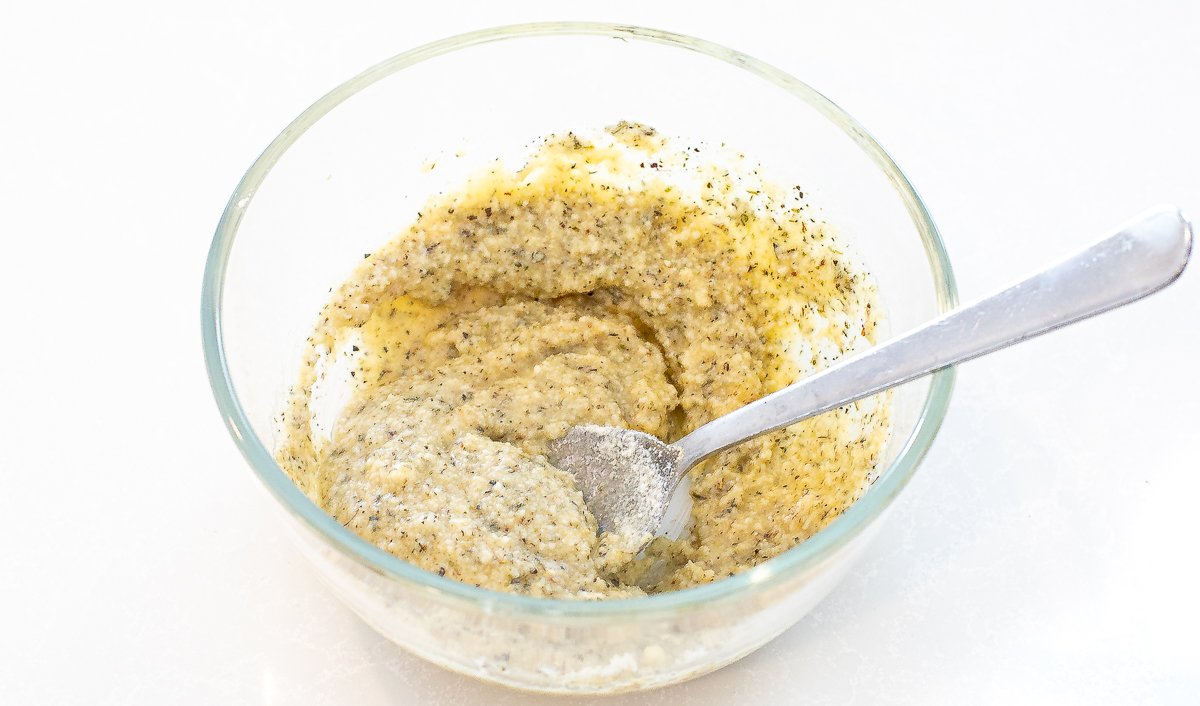 Parmesan butter in a small mixing bowl with a silver spoon.