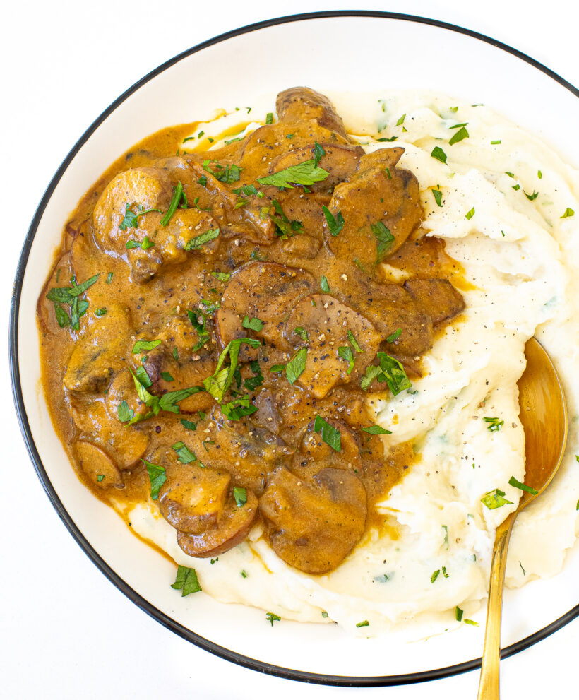 A plate of mashed potatoes topped with mushroom gravy.