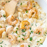 Shrimp and gnocchi in a creamy sauce in a skillet.